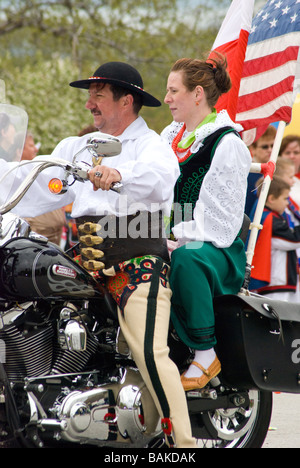 Couple in traditional clothing riding motorcycle in Chicago Polish Parade Stock Photo