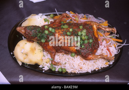 Cuy or guinea pig, a popular dish in Peru and also Ecuador and Quechua speaking parts of Bolivia. Here served with rice, potatoes and salad. Stock Photo