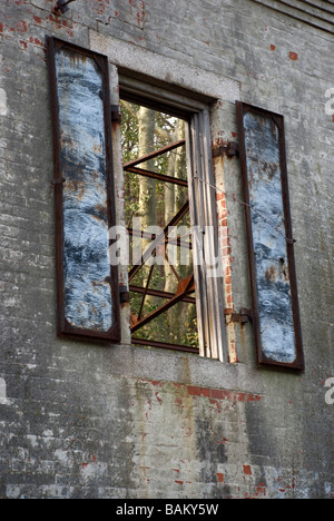 rust rusty iron steel shutters brick wall antique ruin building old vertical abandoned empty vacant open through shutter view Stock Photo