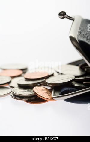 Coins spilling from purse Stock Photo
