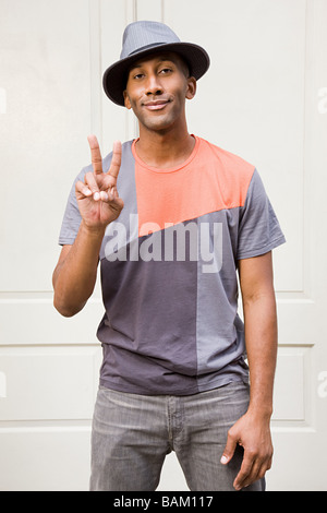 Man wearing fedora and doing peace sign Stock Photo