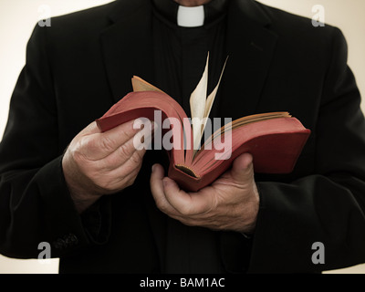 Priest holding a bible Stock Photo