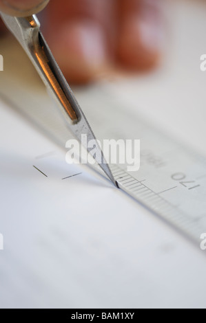 A scalpel and ruler being used to cut paper in print finishing. Stock Photo