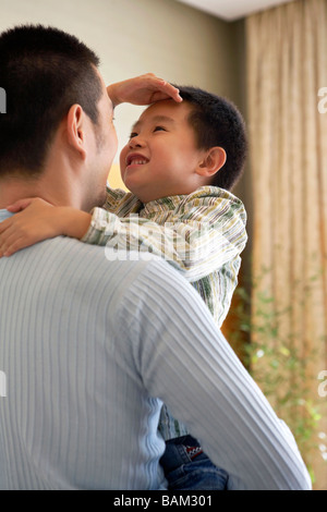 Boy Measuring His Height Against His Father Stock Photo