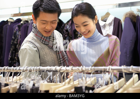 Couple Looking At Clothes In Store Stock Photo