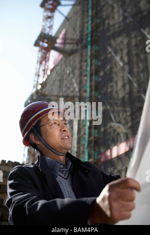 Businessman In Construction Site Wearing Hard Hat Stock Photo