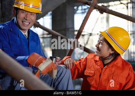 Men In Construction Site Wearing Hard Hats Stock Photo