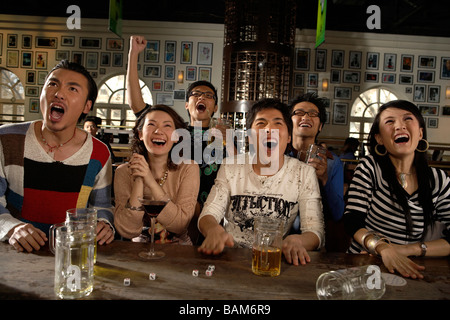 Happy Young People Watching Game In Sports Bar Stock Photo
