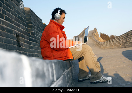 Man Typing On Laptop On Great Wall Of China Stock Photo