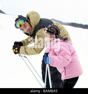 Father And Daughter Skiing Stock Photo