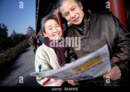 Elderly Couple Holding Newspaper Stock Photo