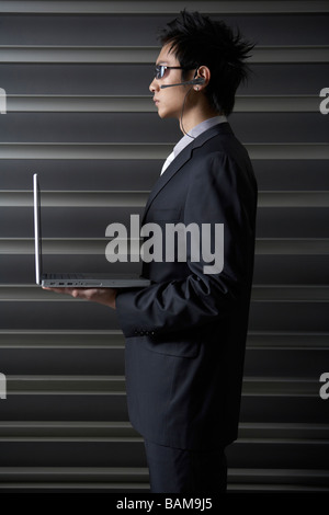 Serious Businessman Holding Laptop Stock Photo