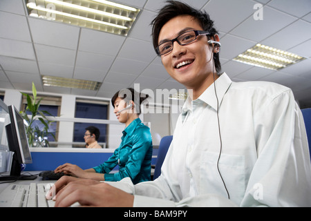 Man And Woman In Call Centre Wearing Headsets Stock Photo