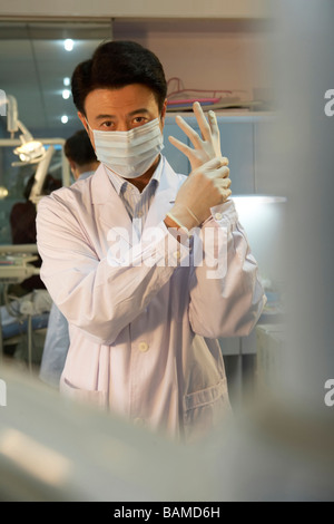 Dentist Putting On Rubber Gloves Stock Photo