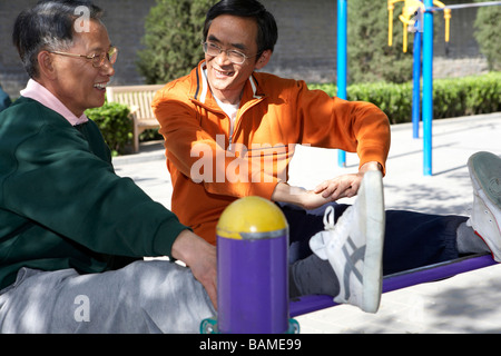 Two Senior Males Stretching Their Legs Before Work Out Stock Photo