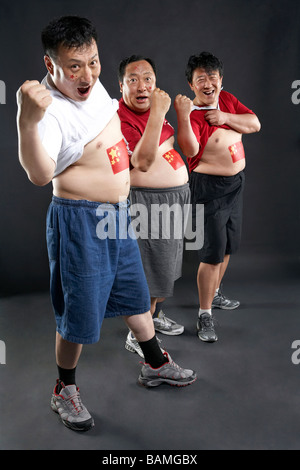 Portrait Of Fans With Flags Painted On Their Stomachs Stock Photo