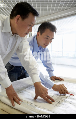 Architects Looking At Building Plans Together Stock Photo
