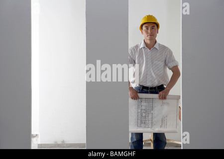 Businessman At A Construction Site In A Hard Hat Holding Blueprints Stock Photo