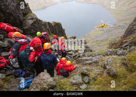 A walker with a compound leg fracture is treated by Langdale Ambleside Mountain Rescue Team in Easy Gully on Pavey Ark Stock Photo