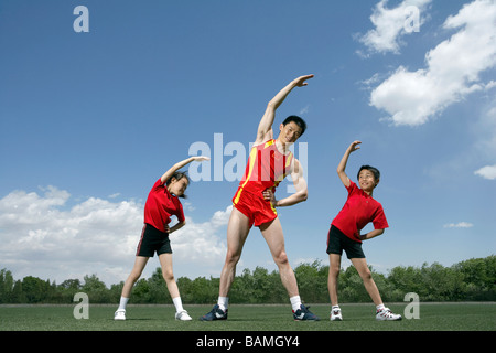 Athletes Stretching In A Field Stock Photo