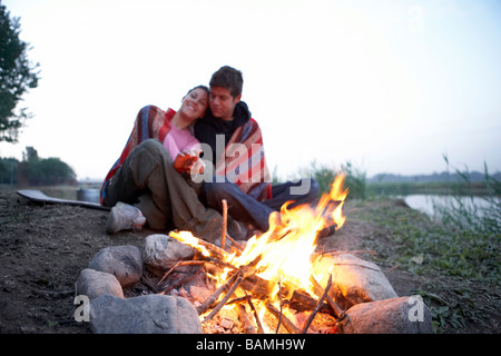 Young Couple Camping In Front Of Fire Stock Photo