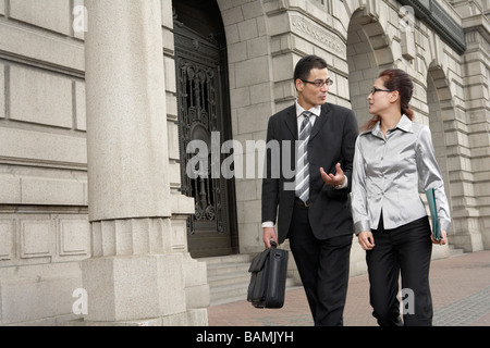 Businessman And Businesswoman Talking To Each Other Stock Photo