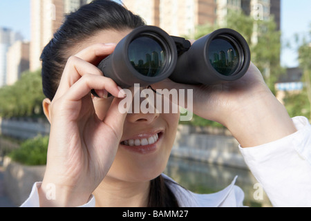 Woman In City Looking Through Binoculars Stock Photo