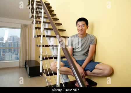 Portrait Of Young Man Sitting On Staircase Stock Photo