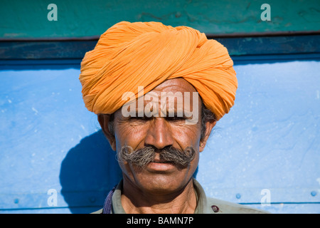 Man wearing a colourful saffron turban at Osian Camel Camp, Osian, Rajasthan, India Stock Photo