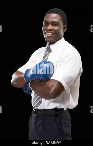 Businessman Wearing Boxing Gloves And Folding Arms Stock Photo