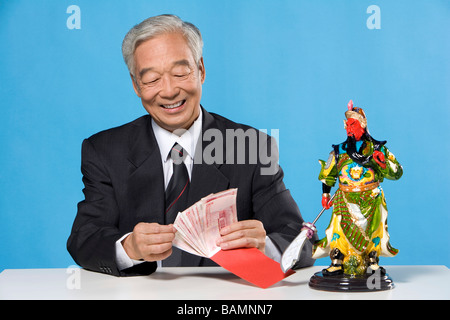 Businessman Sitting At Table With Traditional Objects Stock Photo