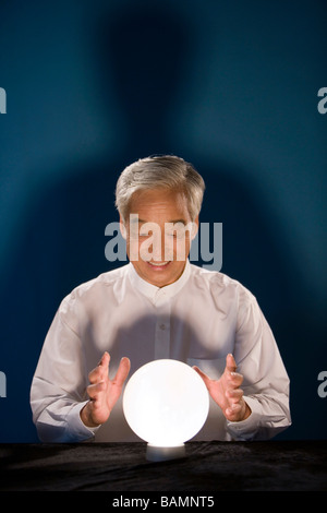 Older Businessman Looking Into Crystal Ball Stock Photo - Alamy