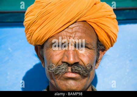 Man wearing a colourful saffron turban at Osian Camel Camp, Osian, Rajasthan, India Stock Photo