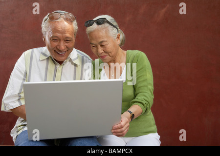 Older Couple Looking At Laptop Computer Together Stock Photo