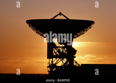 TELECOMMUNICATIONS SATELLITE DISH SILHOUTTED AGAINST AN ORANGE SUNSET SKY CORNWALL ENGLAND Stock Photo