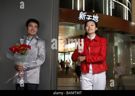Young Man Holding Bunch Of Flowers And Meeting Girlfriend Stock Photo
