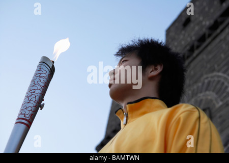Young Man Holds Olympic Torch At The UNESCO World Heritage Site Stock Photo