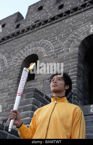 Young Man Holds Olympic Torch At The UNESCO World Heritage Site Stock Photo