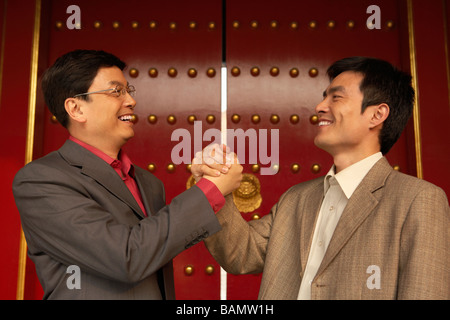 Two Businessmen Shake Hands Outside The Forbidden City Stock Photo