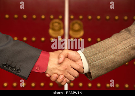 Two Businessmen Shake Hands Outside The Forbidden City Stock Photo