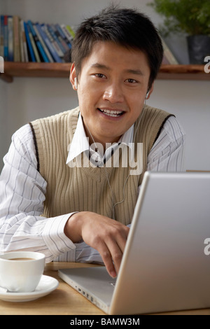 Man Using Laptop Computer With Headphones On Stock Photo