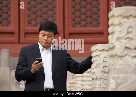 Businessman Using Cellphone In The Forbidden City In Beijing Stock Photo