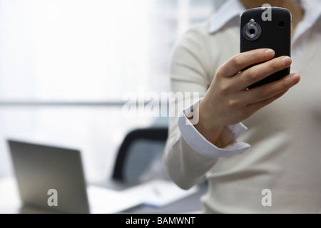 Businesswoman In Office Using Electronic Organizer Stock Photo