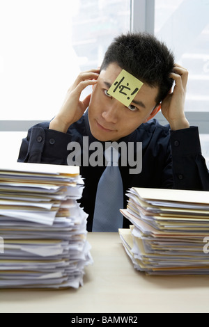 Businessman With Sticky-Note On Forehead Stock Photo