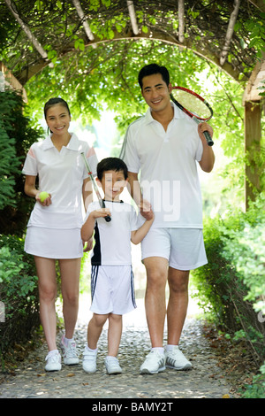 A one child family goes to play tennis Stock Photo