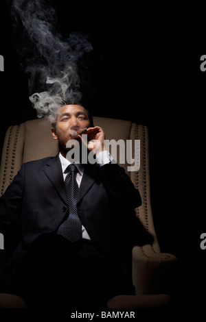 Successful businessman enjoys a cigar Stock Photo