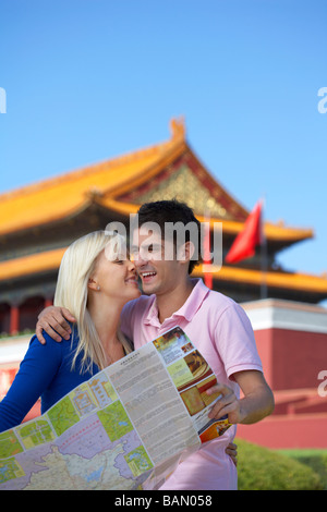 A young couple shares a laugh in front of Tiananmen Gate, Beijing, China Stock Photo