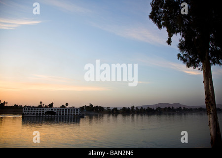 River Nile Cruise boat at sunset looking towards the Valley of the Kings Stock Photo