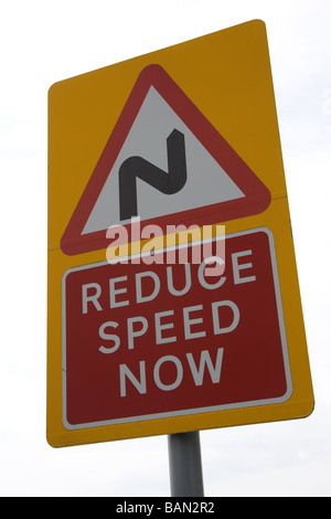 'Reduce Speed Now' sign on UK road Stock Photo