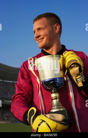 Male goalie triumphantly holding trophy Stock Photo